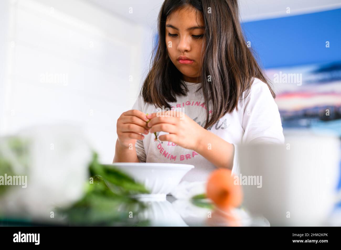 Reinigung und Hilfe im Haus. Entwicklung von Kindern. Kleines Mädchen hilft in der Küche. Kleines Mädchen bereiten gesunde Lebensmittel zu Hause Stockfoto