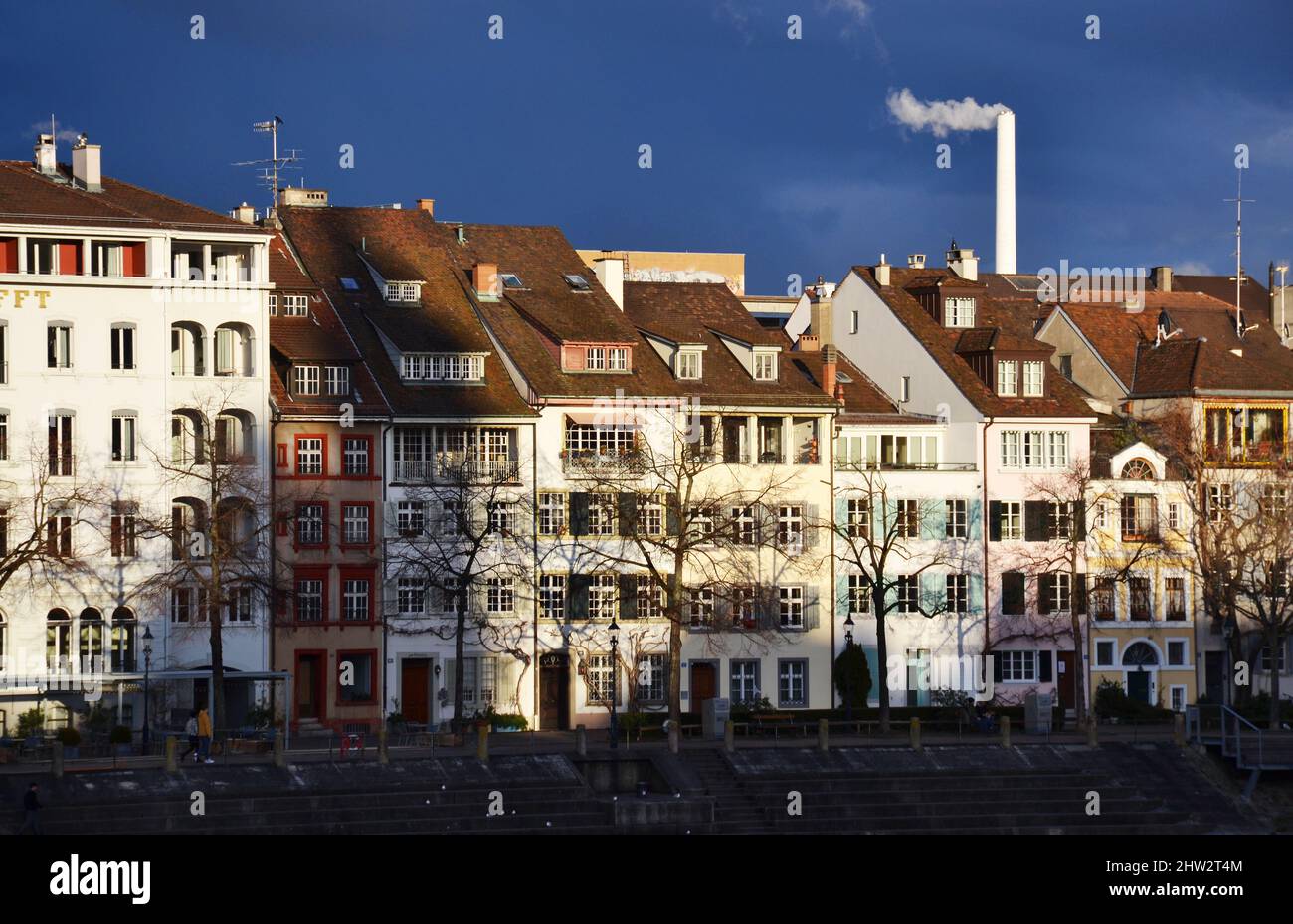 Alte Gebäude am Flussufer bei Sonnenuntergang in Basel, Schweiz Stockfoto