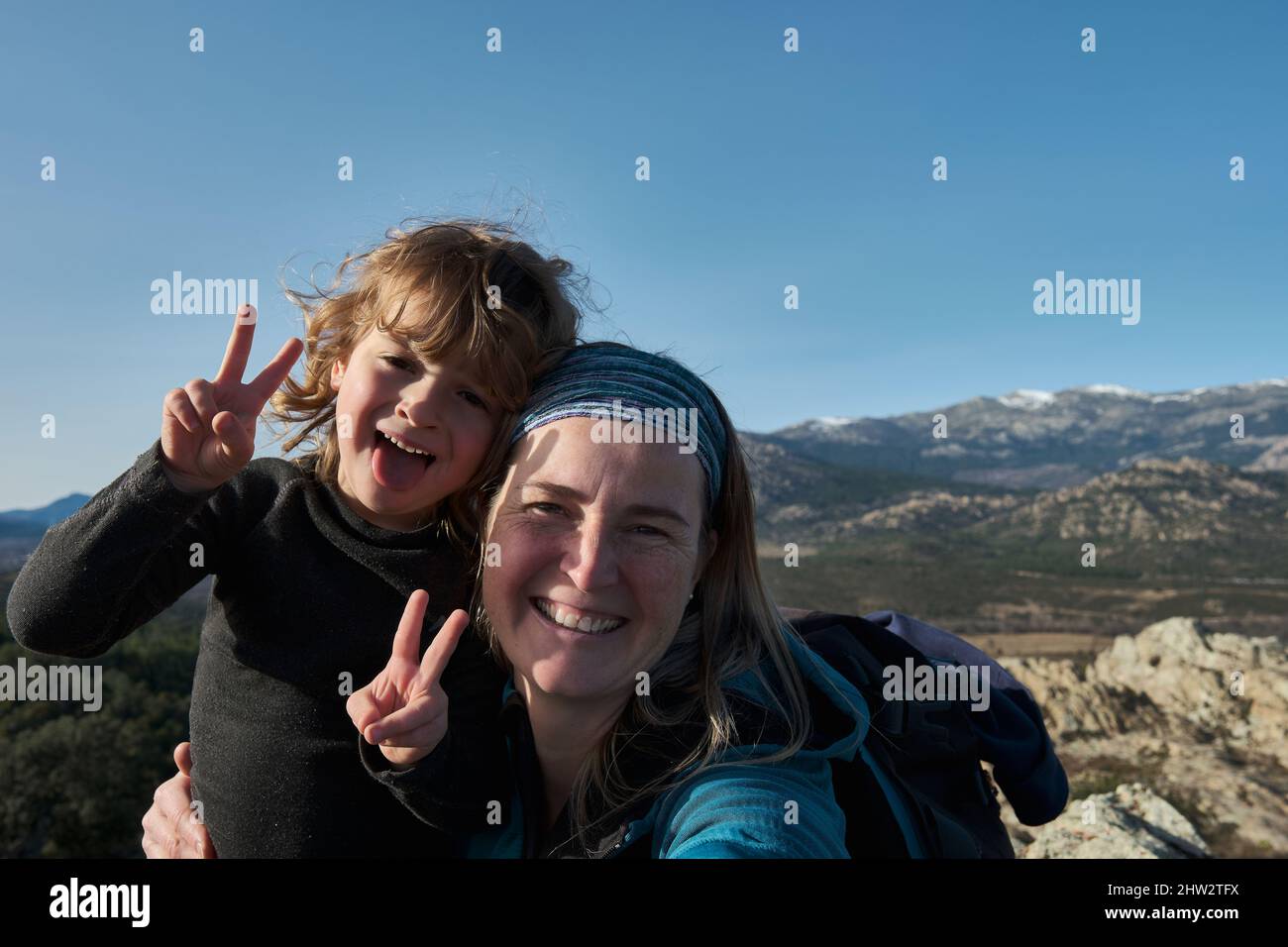 Mutter und Sohn machen Selfies in der Natur, der Junge ist Grimassen und zeigt seine Zunge. Stockfoto