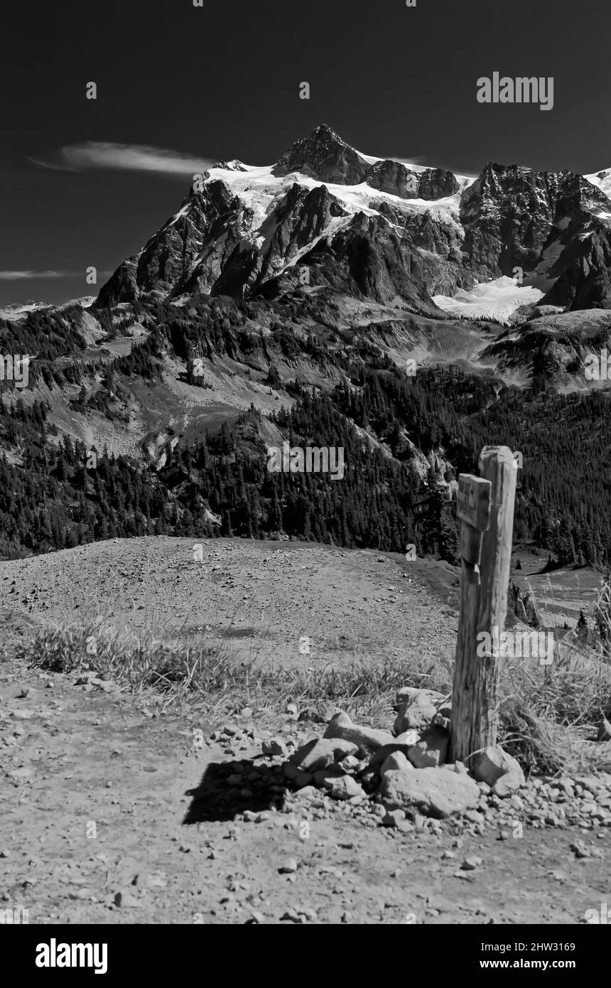Ein gletscherbedeckter Gipfel (Mt. Shuksan), erhebt sich über einen Wegweiser in der Nähe von Mt. Baker, Washington Stockfoto