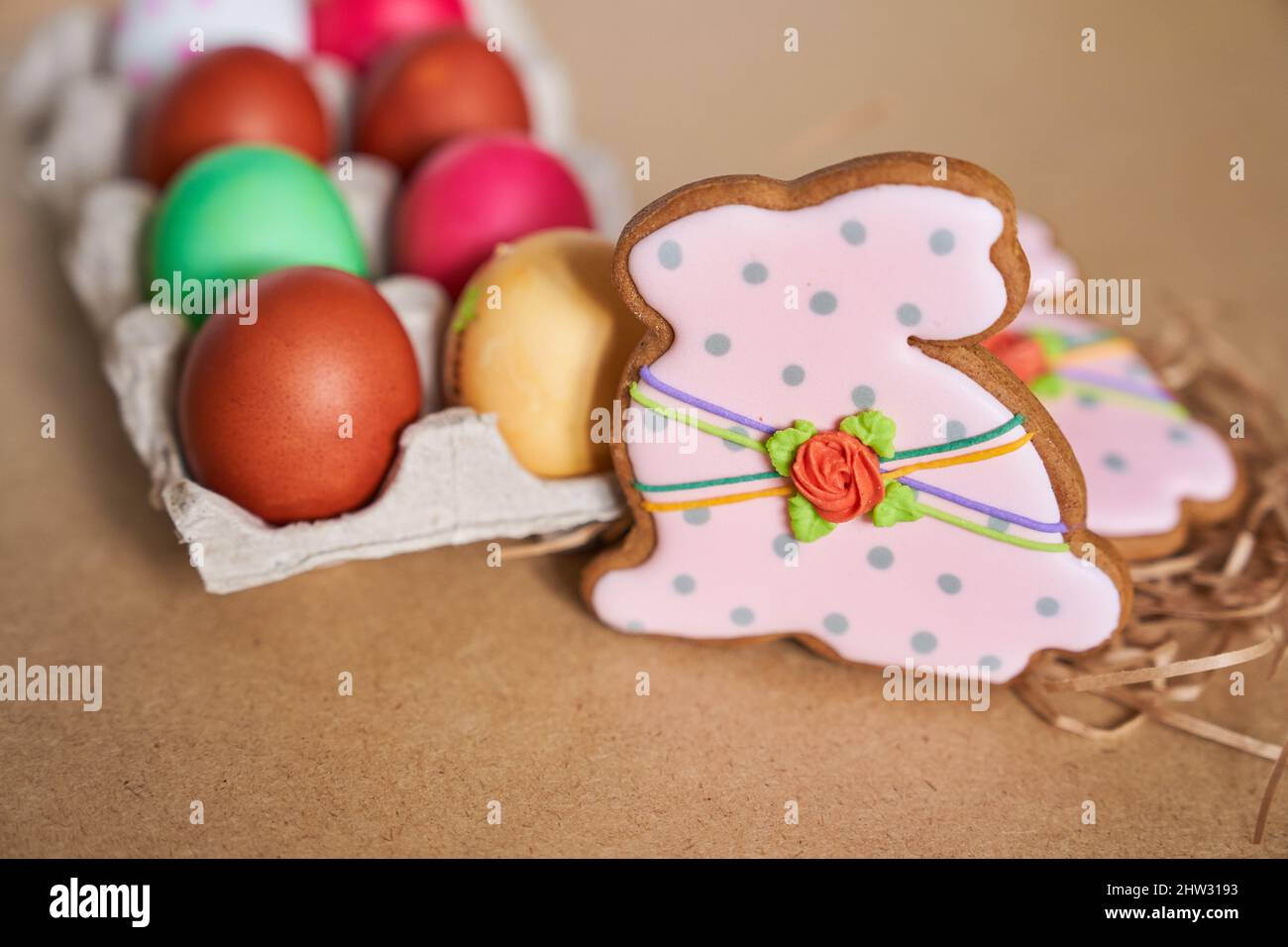 Ostereier und Lebkuchen in Form eines Hasen auf sandigen Hintergrund. Minimales Konzept.mit Platz zum Kopieren. Hochwertige Fotos Stockfoto