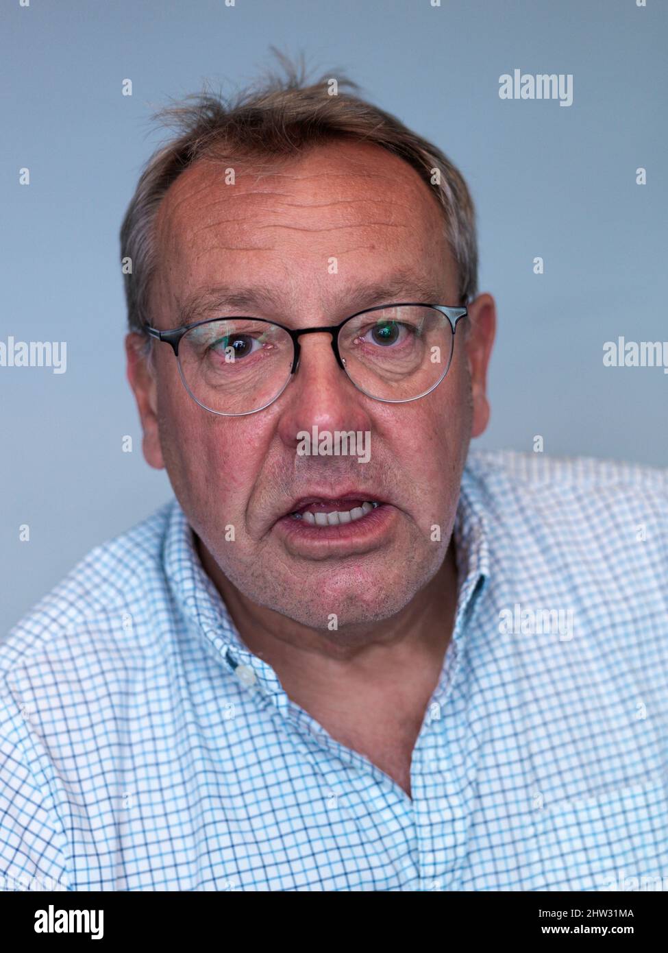 studioportrait eines Mannes mittleren Alters, der überrascht auf die Kamera schaut Stockfoto
