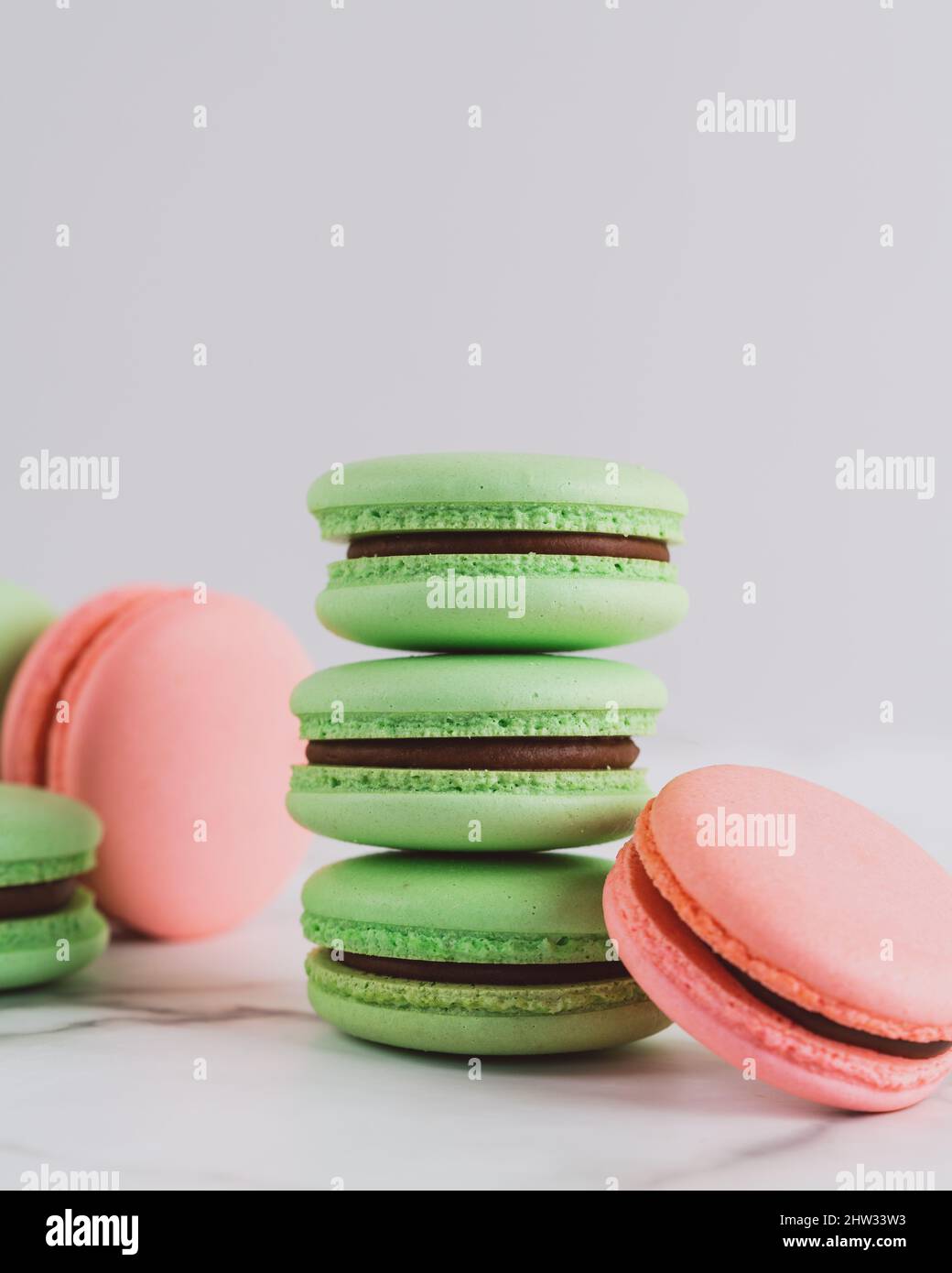 Nahaufnahme von grünen und rosa Macarons auf weißem Hintergrund Stockfoto