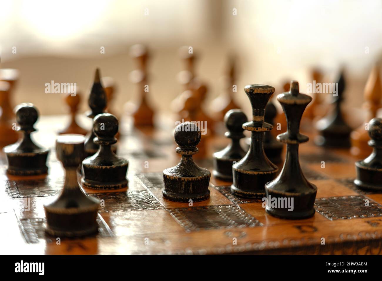Bauer mit anderen Figuren auf dem alten Schachbrett. Stockfoto