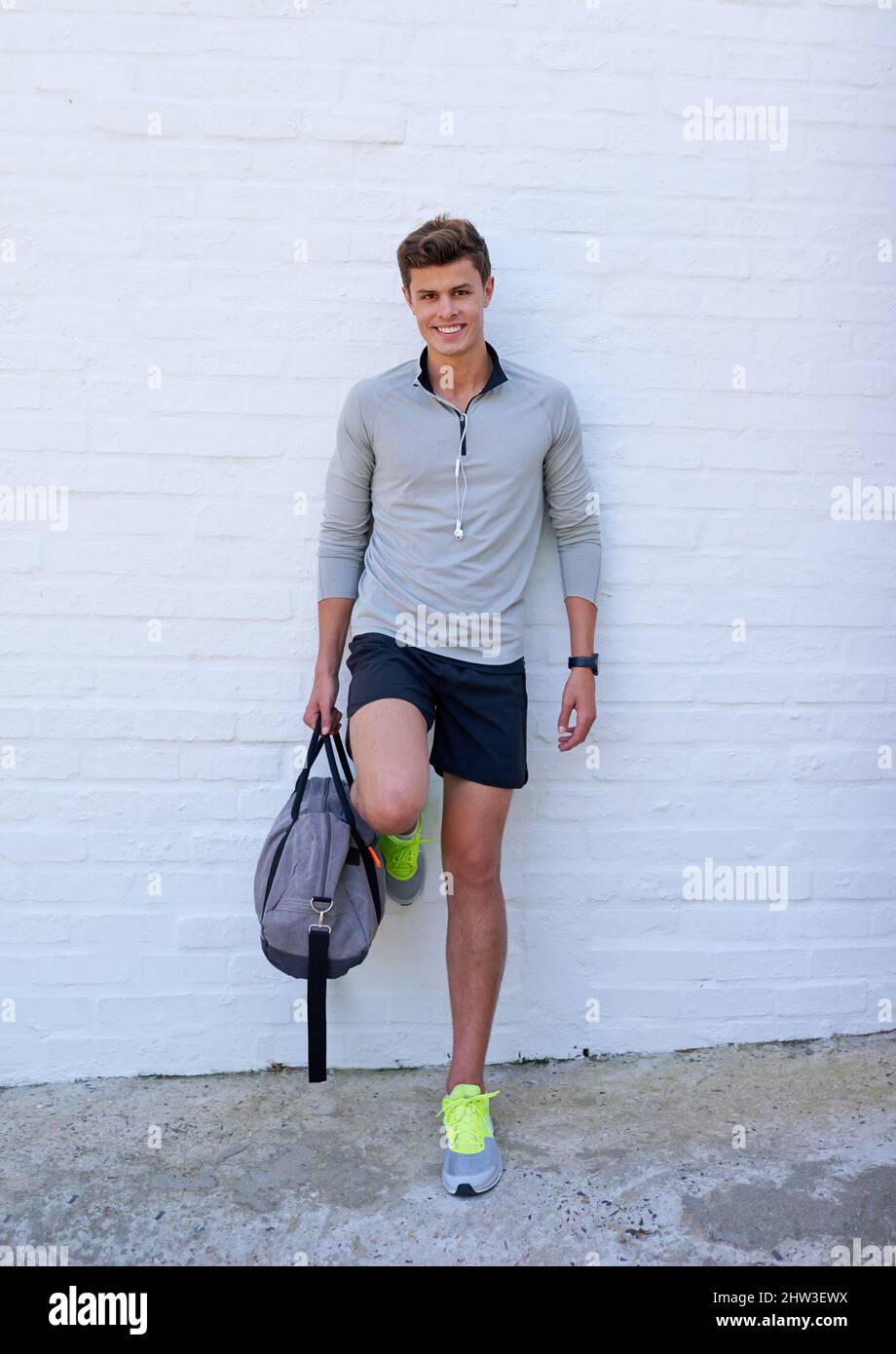 Schlechte Tage können besser gemacht werden, indem man ins Fitnessstudio geht. Aufnahme eines hübschen jungen Mannes, der seine Sporttasche hält und bereit für ein Training ist. Stockfoto