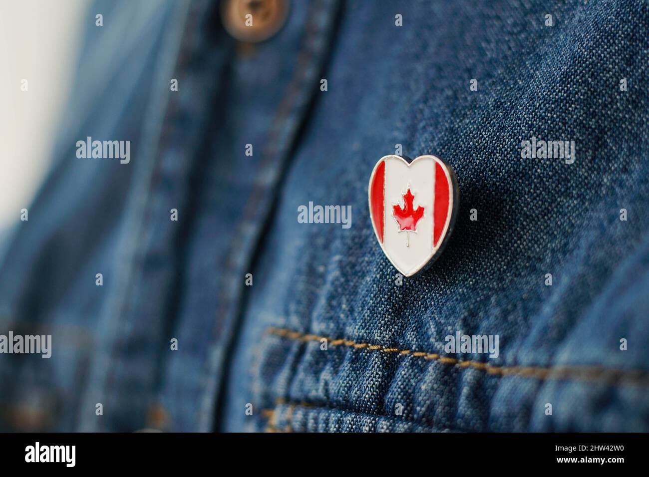 Das kanadische Flag-Symbol ist auf der blauen Jeansjacke eingeklemmt. Konzept des kanadischen Patriotismus. Stockfoto