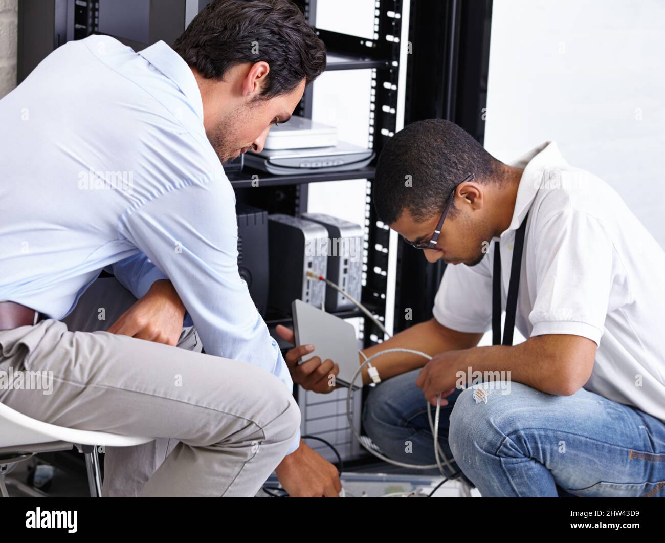 Das Problem finden und beheben. Zwei IT-Experten, die an einem Server arbeiten. Stockfoto