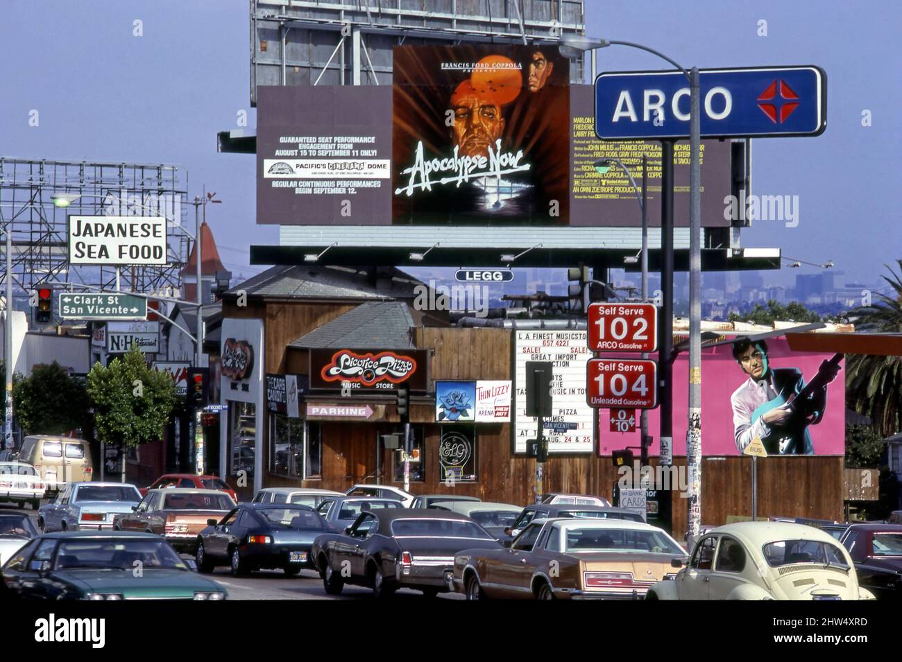 Billboard für den Film Apocalypse Now mit Marlon Brando über dem Licoirce Pizza Plattenladen auf dem Sunset Strip mit Verkehr und Gas für einen Dollar im Jahr 1979, LOS ANGELES, CA Stockfoto