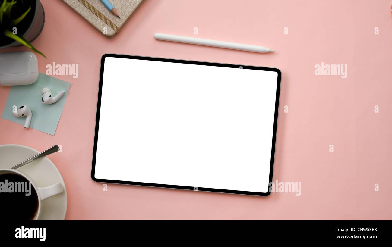 Schöne pastellrosa Arbeitsplatz Hintergrund mit digitalen Tablet weißen Bildschirm Mockup und Office-Zubehör. Draufsicht, flach legen Stockfoto
