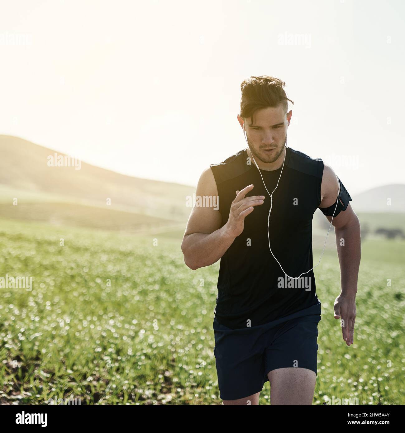 Auf lange Sicht in der IT. Kurzer Schuss eines hübschen jungen Mannes, der im Freien läuft. Stockfoto