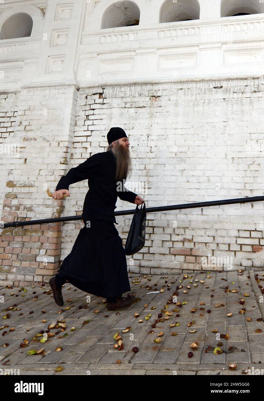 Ein ukrainisch-orthodoxer Priester, der am Lavra-Kloster in Kiew, Ukraine, vorbei geht. Stockfoto