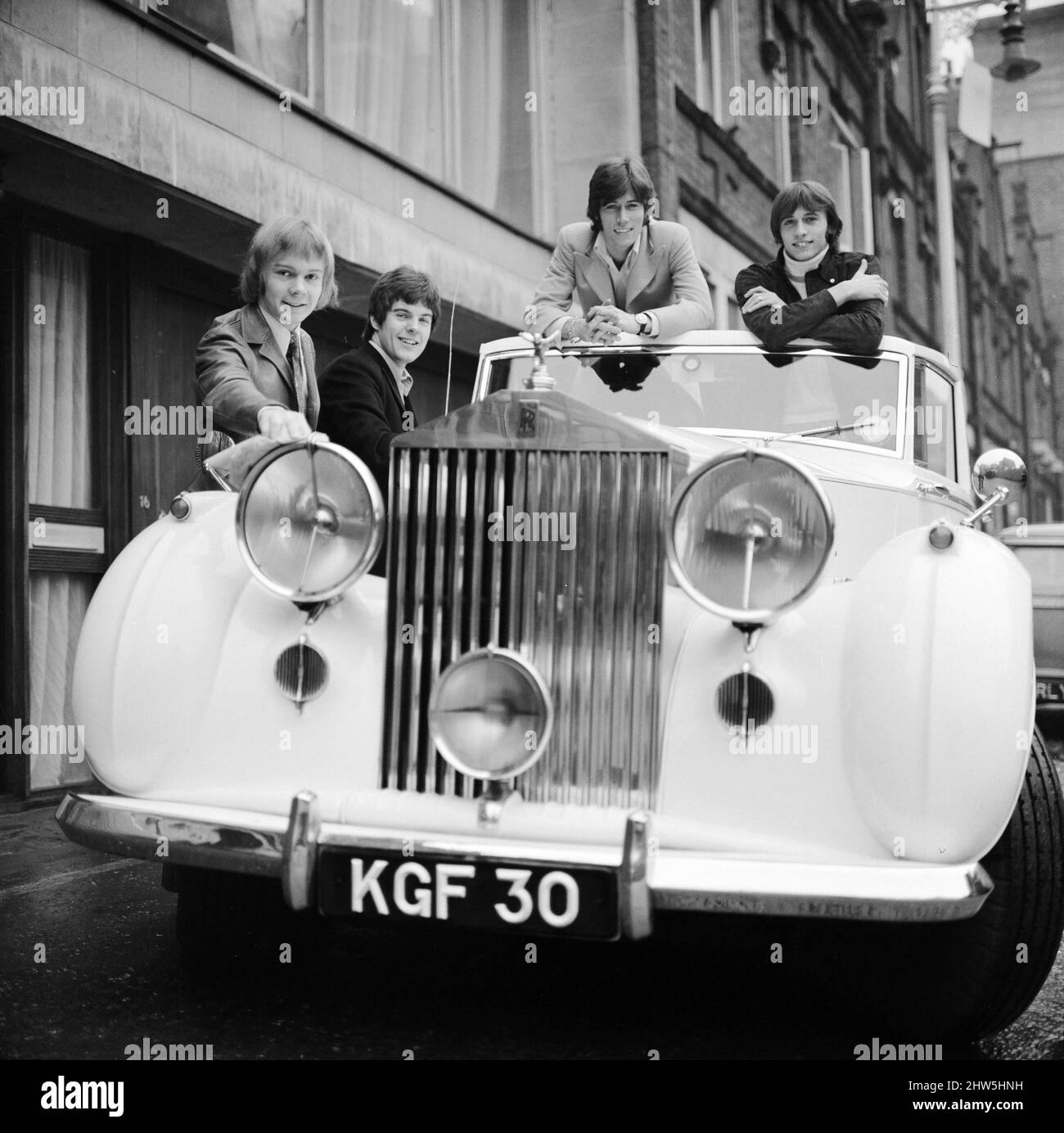 Die Bee Gees untersuchen ein frühes weihnachtsgeschenk von Agent Robert Stigwood, einem Rolls Royce Silver Wraith aus dem Jahr 1948, 12.. Dezember 1967. Das Auto wurde als besonderes Geschenk zur Feier des Erzielens von 1 Millionen Rekordverkäufen ihres einzigen Massachusetts überreicht. Vier der fünf Mitglieder der Gruppe schauen über das Auto und geben ihm einen polierten und sauberen Eindruck. Herr Stigwood ließ das Auto komplett umpolstern und lackieren & der Motor wurde überholt. Im Bild: Colin Peterson, Vince Melouney, Barry Gibb & Robin Gibb in Adams Row, Mayfair (Robin Gibb war nicht für Fotos verfügbar) Stockfoto