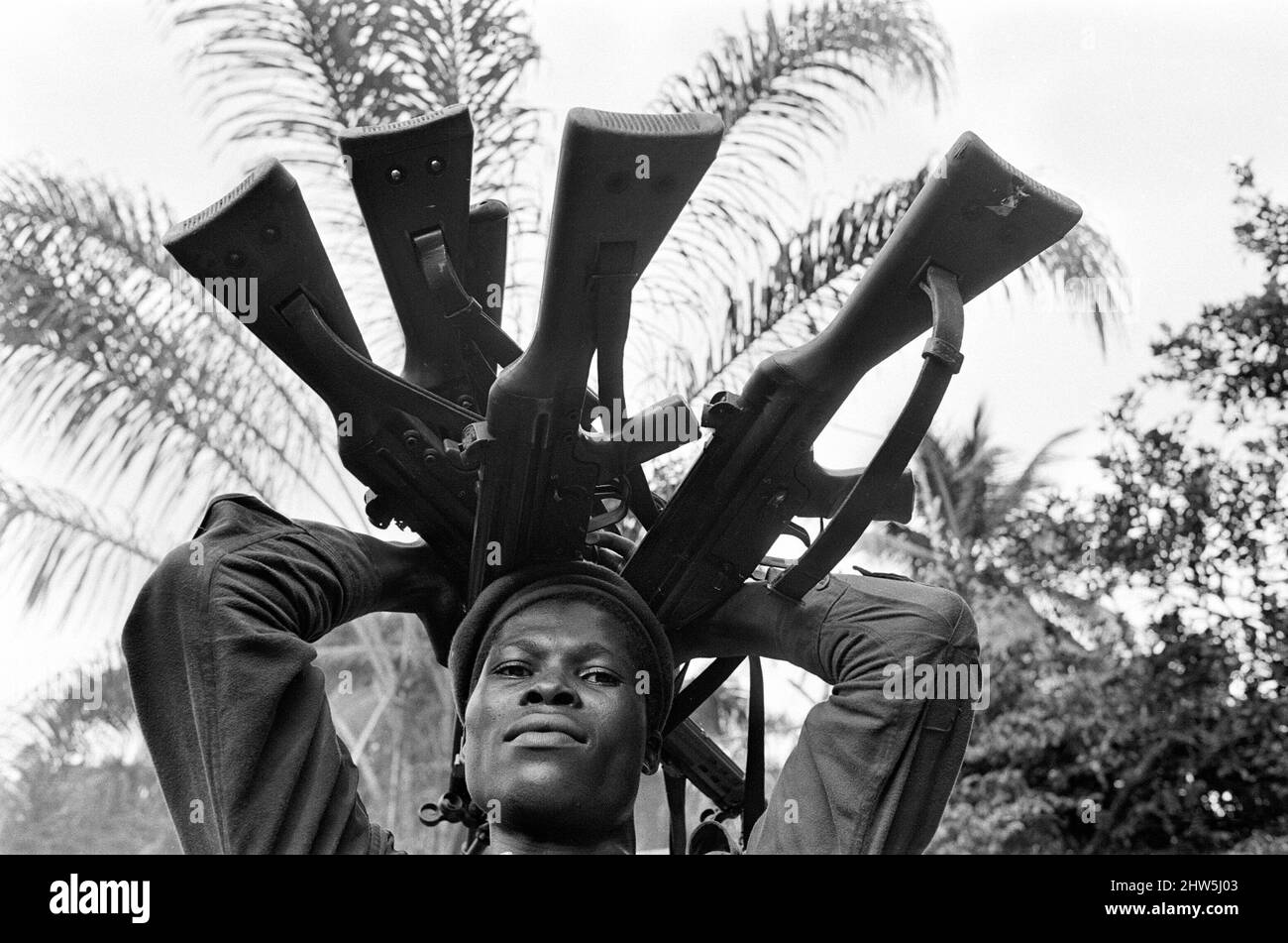 Ein biafranischer Soldat, der hier während des Konflikts in Biafran eine Auswahl von Gewehren in der Hand hielt, am 11.. Juni 1968. Der nigeranische Bürgerkrieg, auch bekannt als Biafrankrieg, dauerte zweieinhalb Jahre, vom 6. Juli 1967 bis zum 15. Januar 1970, und wurde gekämpft, um der Abspaltung von Biafra von Nigeria entgegenzuwirken. Die indigenen Igbo-Bewohner von Biafra fühlten sich nach der Unabhängigkeit von Großbritannien nicht mehr mit der nordeuropäischen Bundesregierung koexistieren können. Politische, wirtschaftliche, ethnische, kulturelle und religiöse Spannungen kochten schließlich nach dem Militärputsch von 1966 in einen Bürgerkrieg über, dann in einen Gegenkrieg Stockfoto