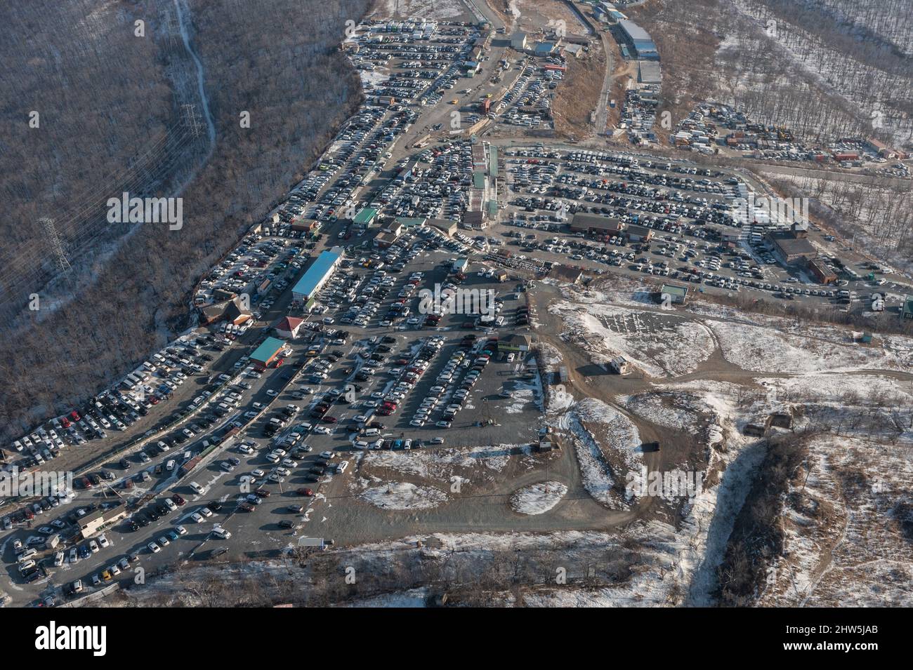 Reihen von stehenden Autos auf dem Automarkt gefilmt von oben. Verkauf von Gebrauchtwagen aus Japan gebracht. Stockfoto