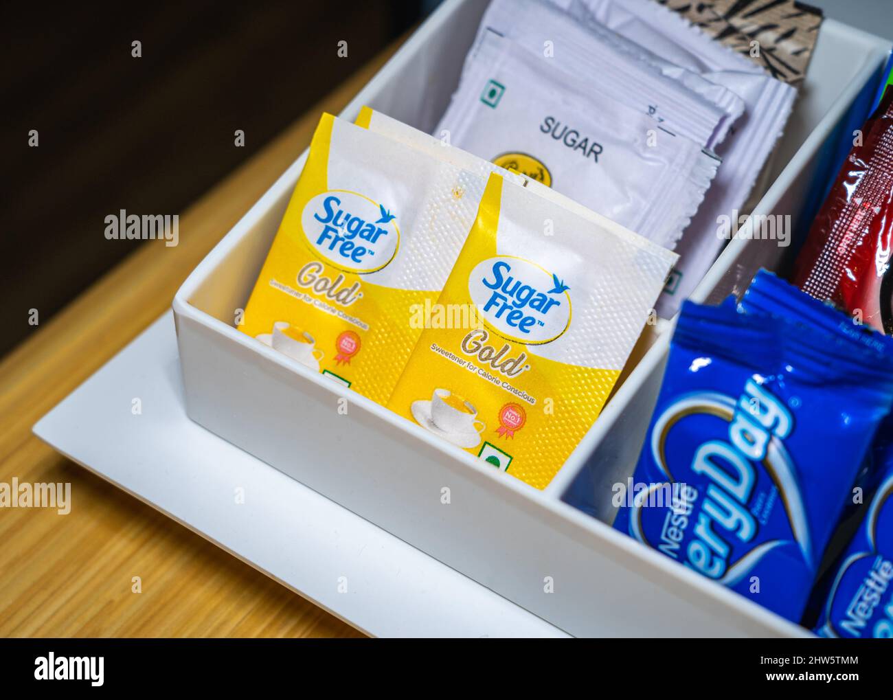 Selektiver Fokus von zwei Päckchen Zuckerfreies Gold-Süßstoff in einem weißen Kunststoffgestell. Stockfoto