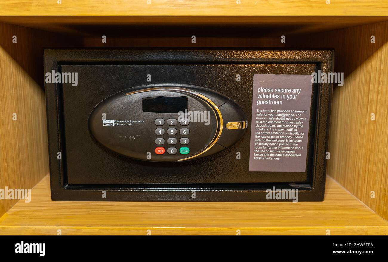 Ein elektronischer schwarzer Safe in einem Holzregal. Stockfoto