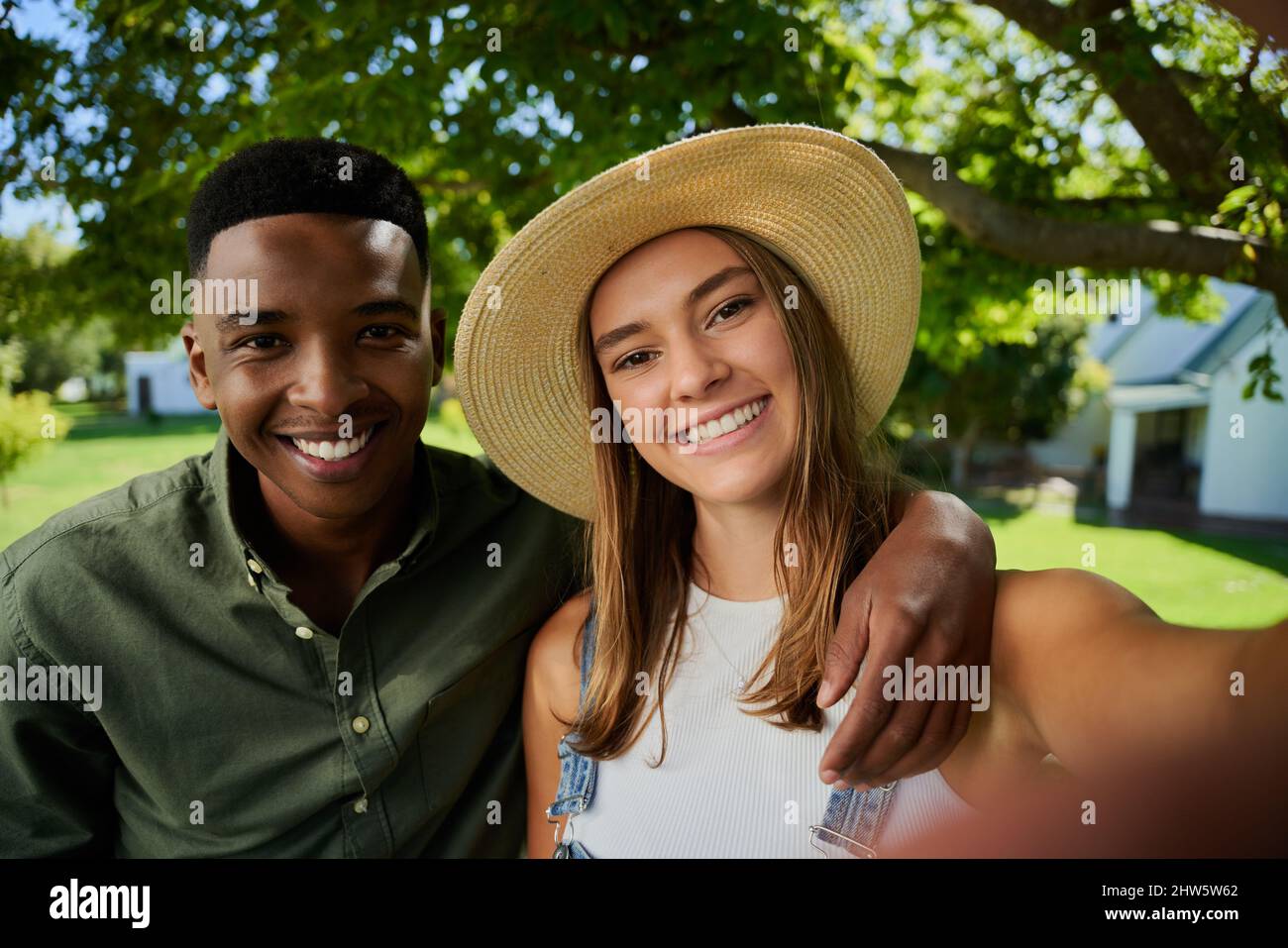 Männliche und weibliche Landwirte mit gemischter Rasse, die im Freien stehen und Selfie mit einem Mobilfunkgerät machen Stockfoto