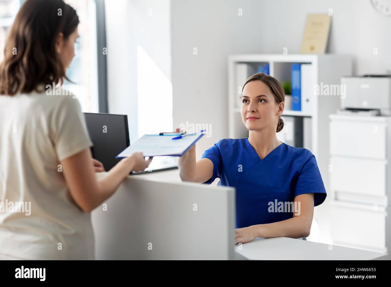 Doktor mit Zwischenablage und Patient im Krankenhaus Stockfoto