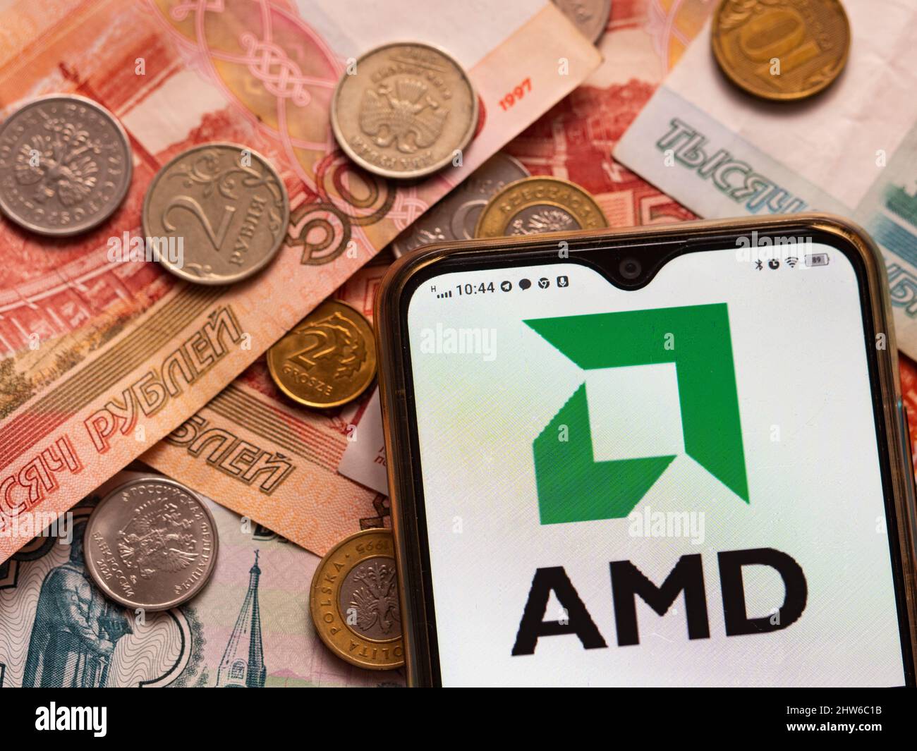 In dieser Abbildung wird das AMD-Logo auf einem Smartphone auf dem Hintergrund des russischen Oney angezeigt. AMD hat sich den Sanktionen gegen Russland angeschlossen. Stockfoto