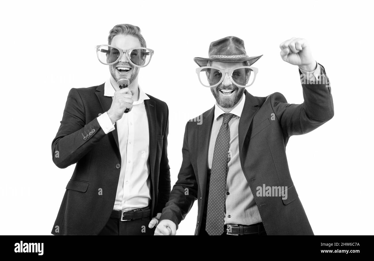 Glückliche Mitarbeiter haben Spaß, Karaoke in lustigen Brillen und formalwear singen, Firmenfeier Stockfoto