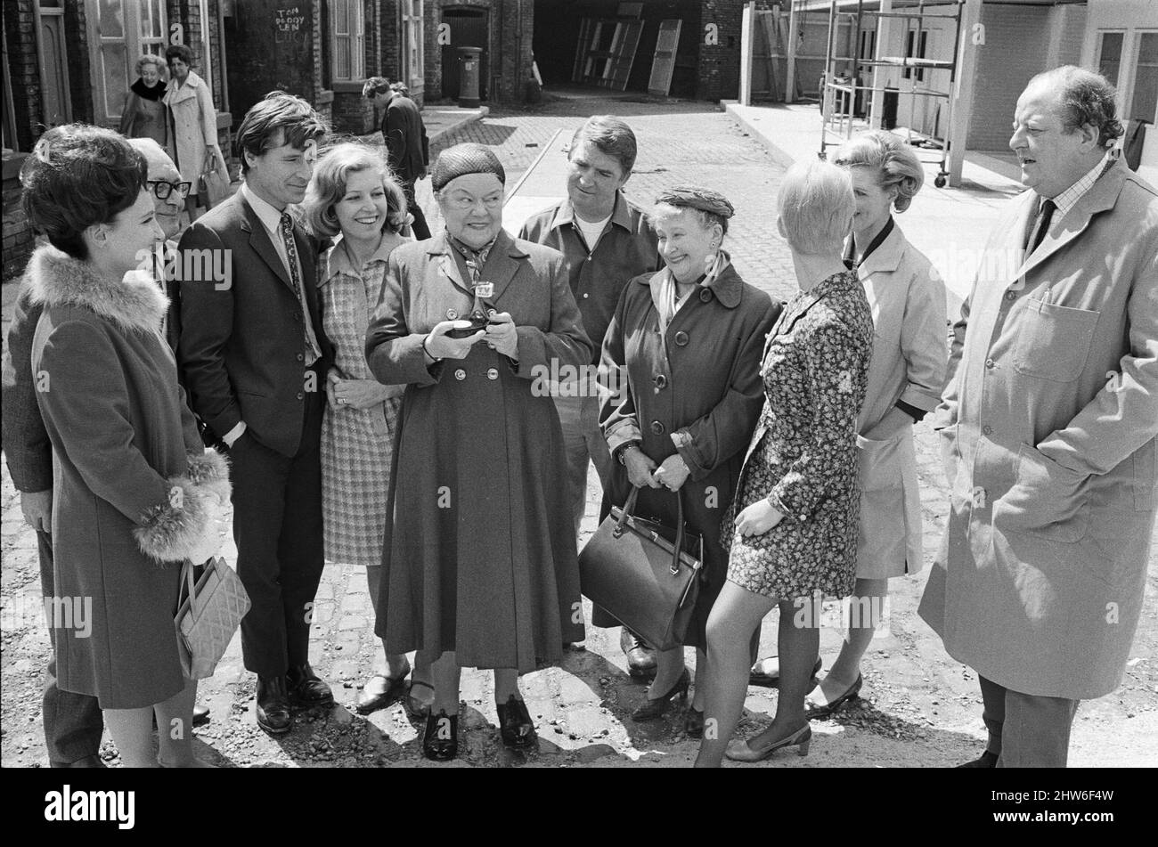Eine neue Straßeneinstellung für die „Coronation Street“. Granada TV hat ein Outdoor-Set für einige der Szenen gebaut. Im Bild sehen Sie die Darsteller Emily Nugent (Eileen Derbyshire), Ken Barlow (William Roache), Valerie Barlow (Anne Reid), Ena Sharples (Violet Carson), Len Fairclough (Peter Adamson), Jenny Sutton (Mitzi Rogers), Margaret Clegg (Irene Sutclife) und Leslie Clegg (John Sharpe). 18. Mai 1968. Stockfoto