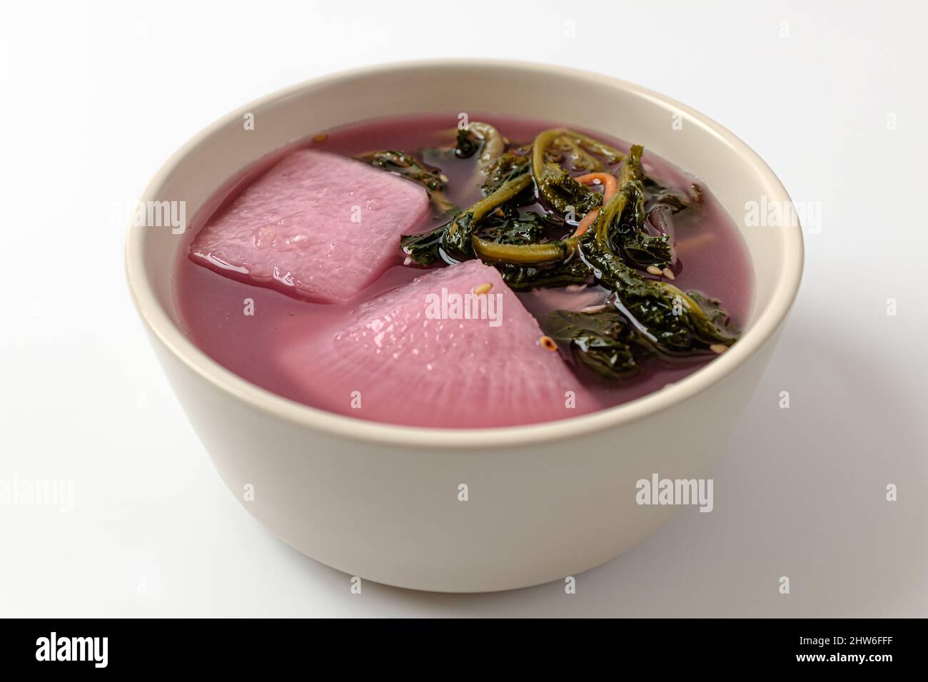 Roter Senfgrün wässriges Kimchi auf weißem Hintergrund Stockfoto