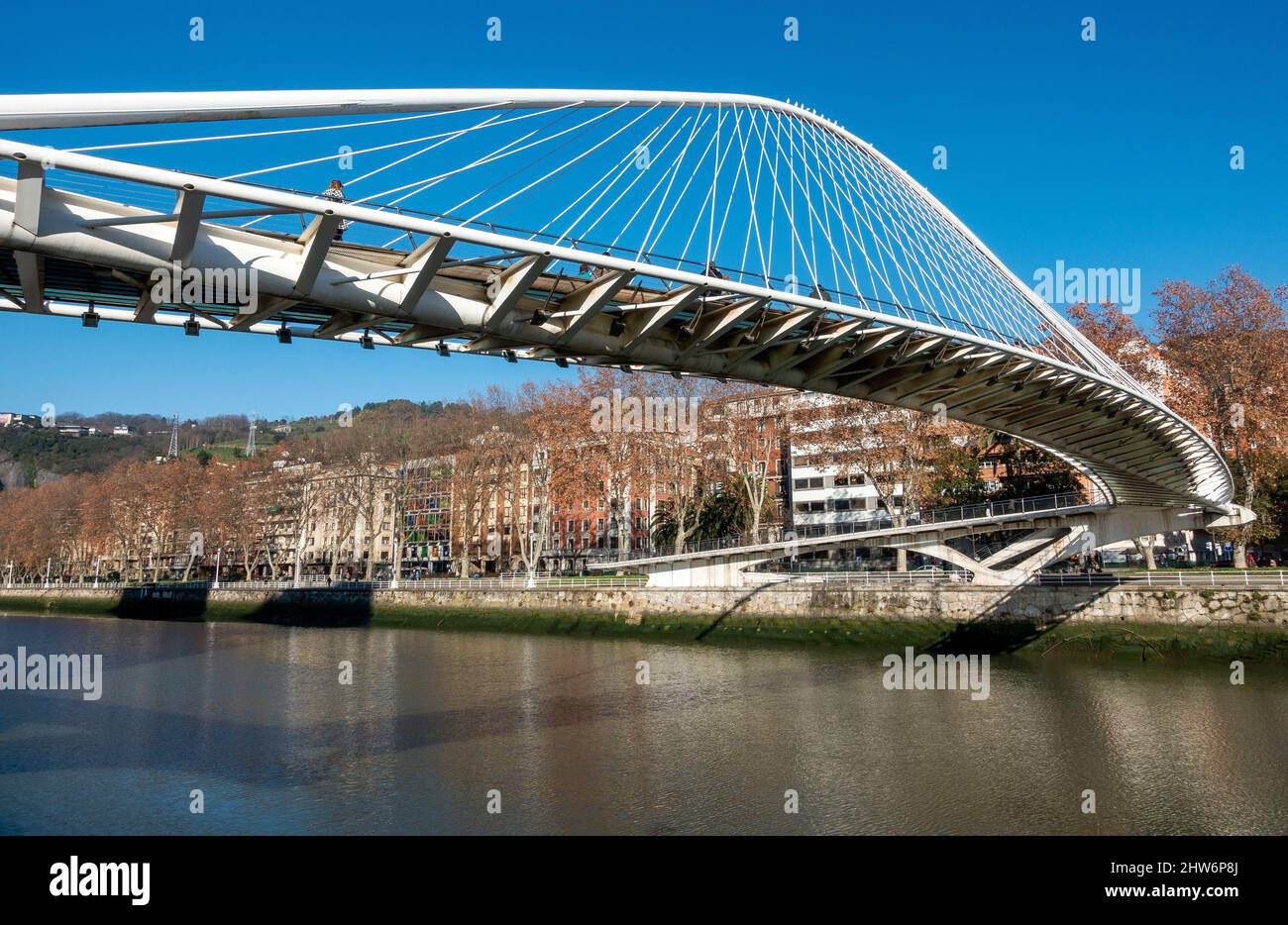 Die Zubizuri (baskisch für „weiße Brücke“) ist eine Fußbrücke mit gebundenem Bogen, die sich über den Fluss Nervion in Bilbao, Spanien, erstreckt Stockfoto