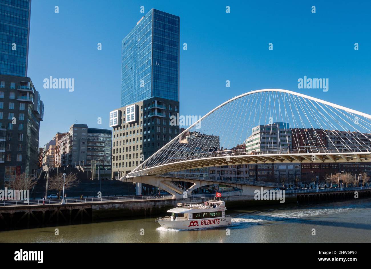 Die Zubizuri (baskisch für „weiße Brücke“) ist eine Fußbrücke mit gebundenem Bogen, die sich über den Fluss Nervion in Bilbao, Spanien, erstreckt Stockfoto