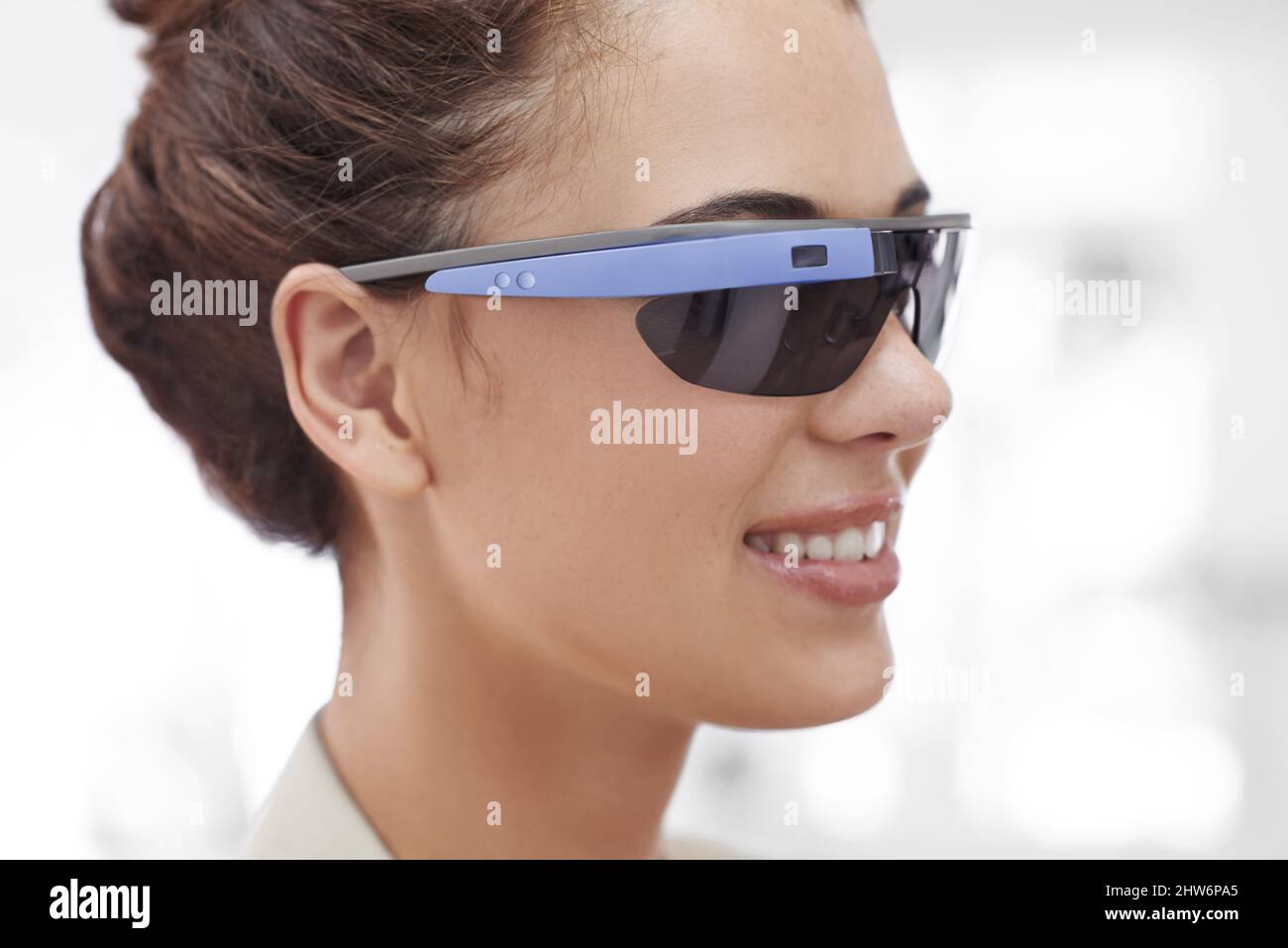 Eine kurze Aufnahme einer attraktiven jungen Frau in einer Brille mit Internetzugang. Die in diesem Bild angezeigten kommerziellen Produkte oder Designs repräsentieren Stockfoto