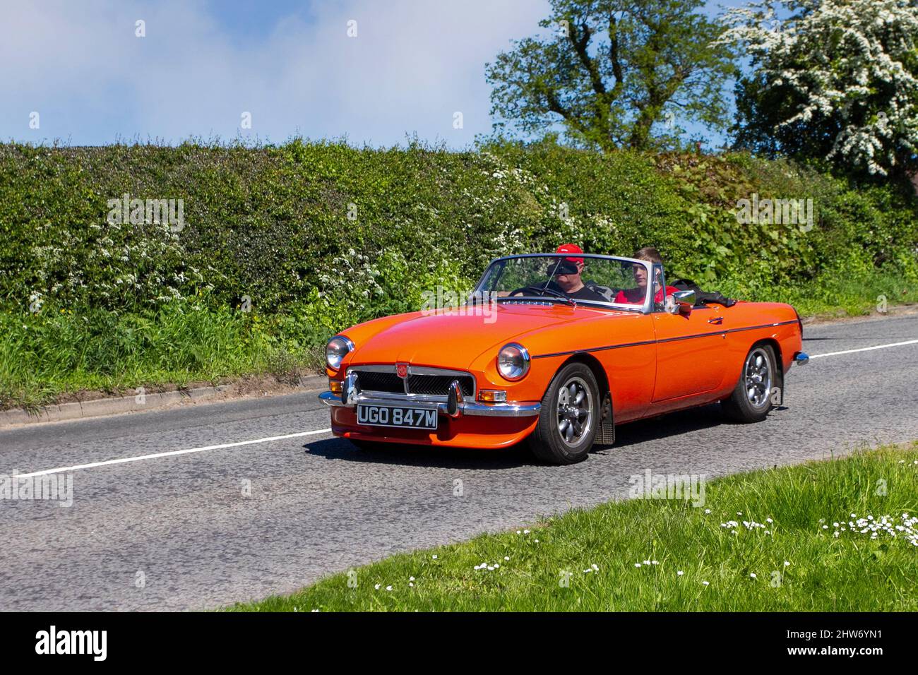 1973 70s siebziger orangefarbener MG B Zweisitzer-britischer Sportwagen auf dem Weg zur Capesthorne Hall Classic May Car Show, Ceshire, Großbritannien Stockfoto