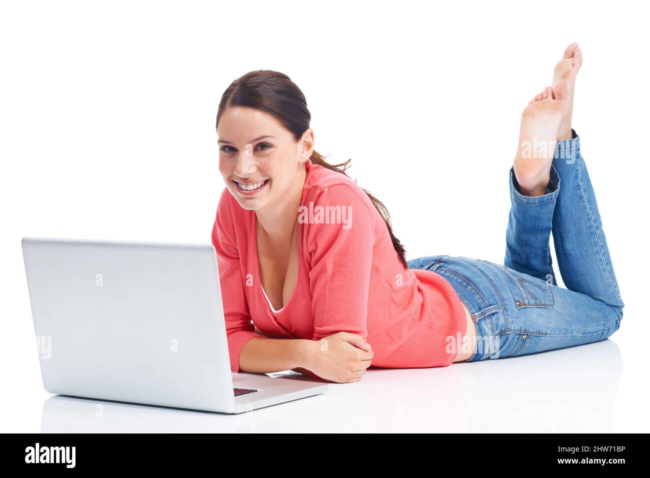 Entspannen, wie es ihr gefällt. Glückliche junge Frau, die sich entspannt, während sie ihren Laptop benutzt. Stockfoto