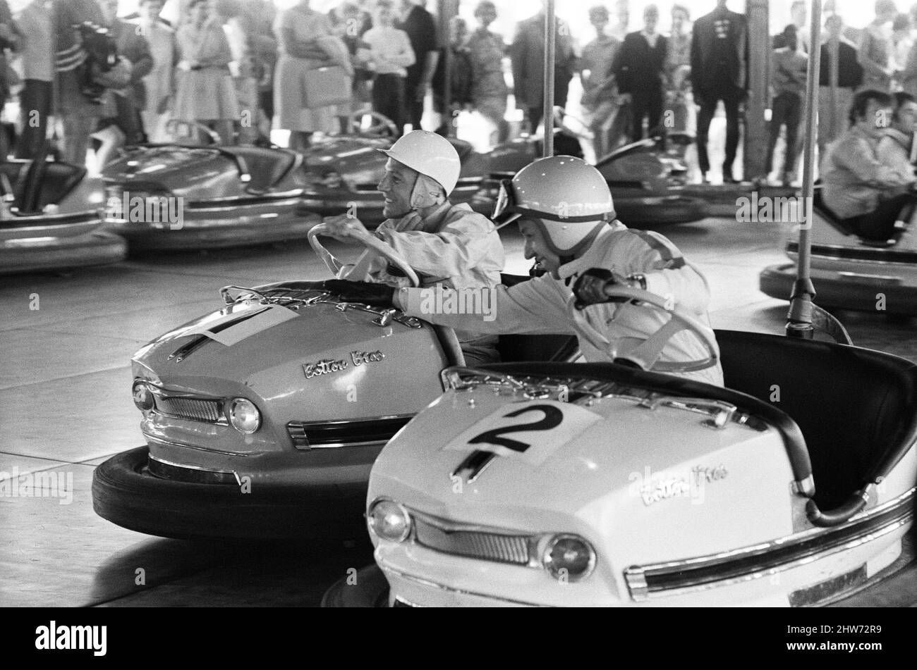 Weltmeister auf den DodGems. In einer neuen Fernsehshow mit dem Titel „Nice Time“ in Granada werden die Grand Prix-Piloten Stirling Moss, John Surtees und Denny Hume auftreten. Diese Ausgabe wurde auf der Battersea Fun Fair auf den Dodgem Cars gedreht, wo ein Mini-Grand-Prix stattfand. Im Bild, zwielichtige Arbeit von Surtees, als er sich während der Session nach Stirling Moss's Auto schnappt. 30.. Juli 1968. Stockfoto