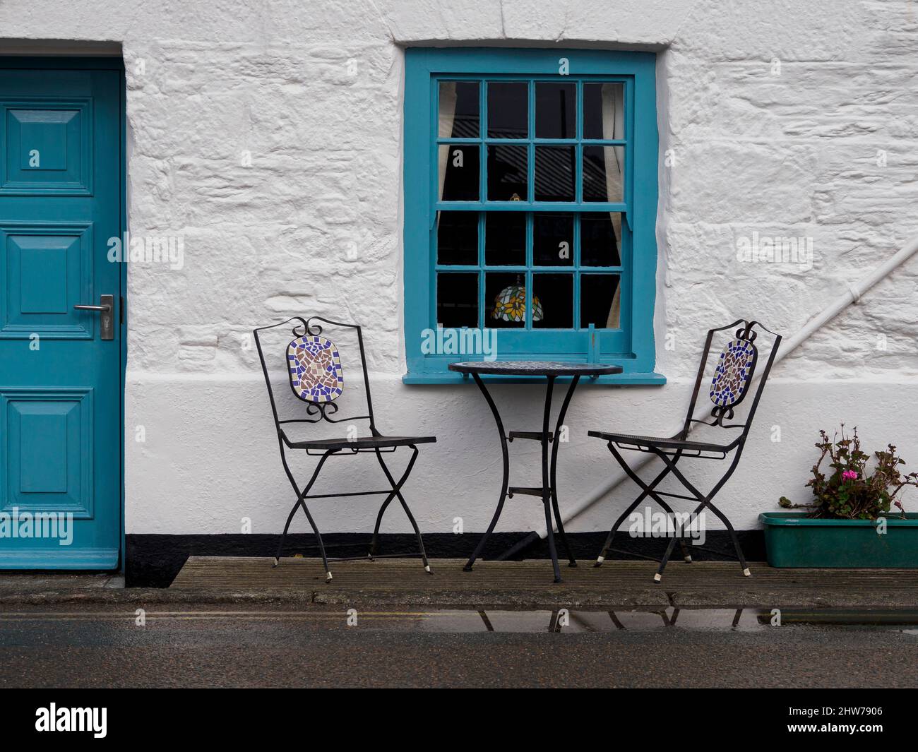 Tisch und Stühle unter dem Fenster, Cornwall, Großbritannien Stockfoto