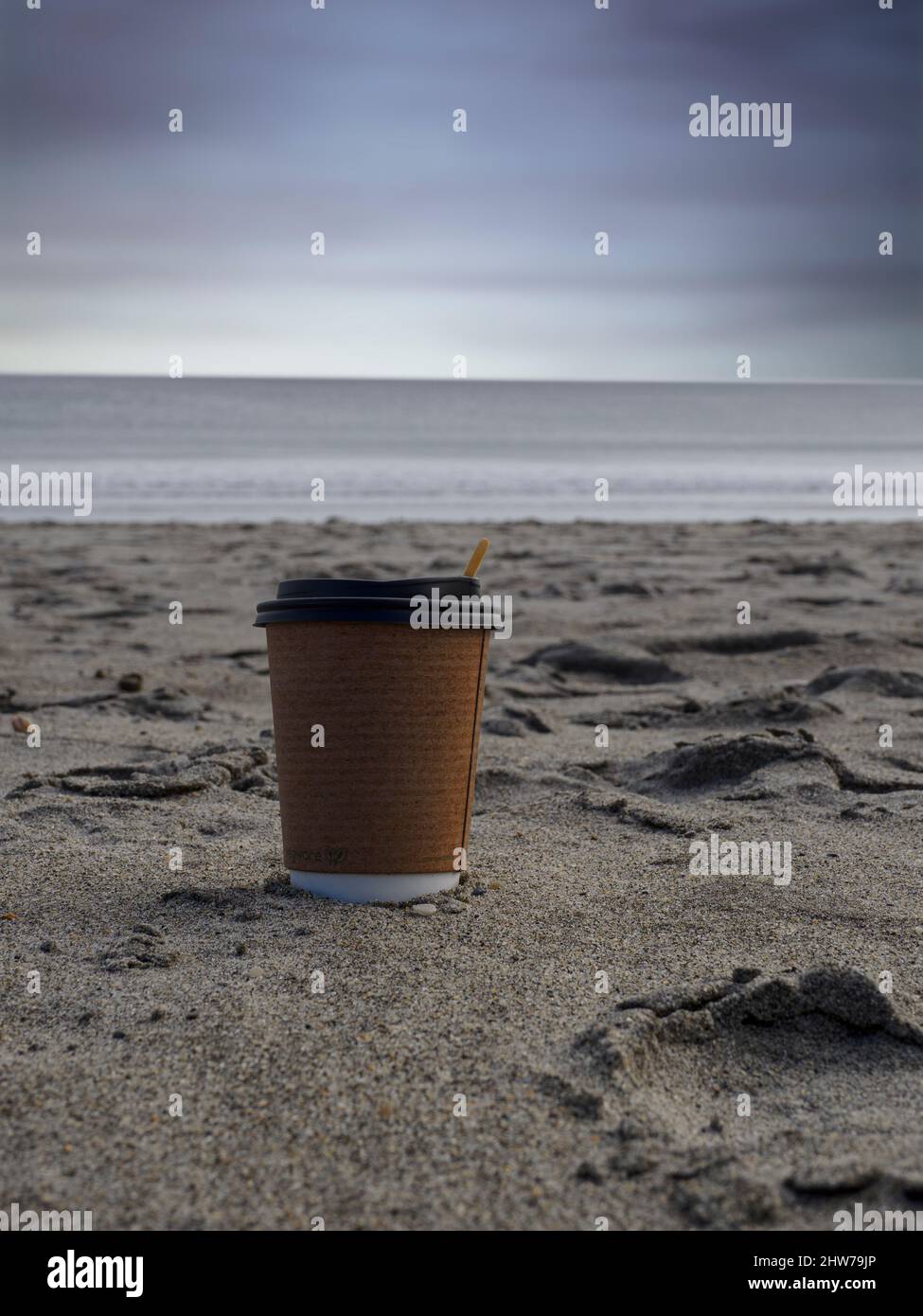 Kaffeetasse zum Mitnehmen am Strand, Pentewan, Cornwall, Großbritannien Stockfoto