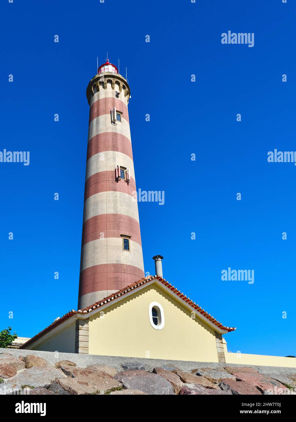 Niedriger Winkel des größten Leuchtturms in Portugal gegen den blauen wolkenlosen Himmel am Strand von Barra Stockfoto