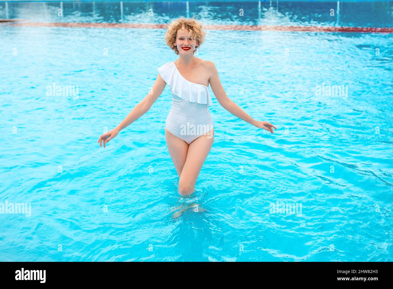 Schöne lächelnde Rothaarige (Ingwer) Frau Porträt genießen das Leben im Schwimmbad im Sommer Tag. Sommer, Entspannung, Wellness, Reisen, Erholung Stockfoto