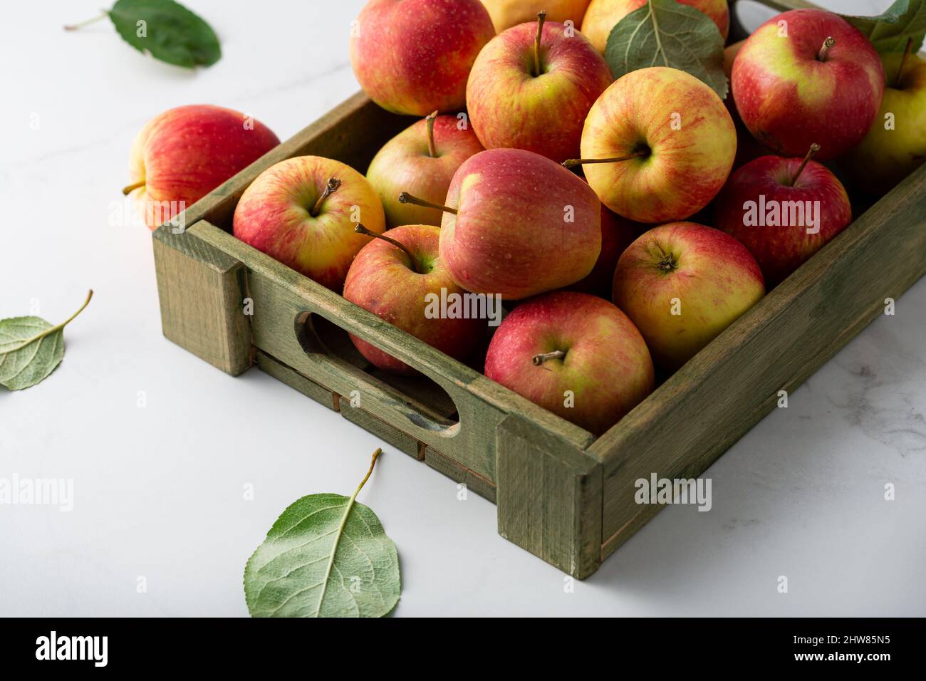 Rote und gelbe Äpfel in Holzkiste Stockfoto