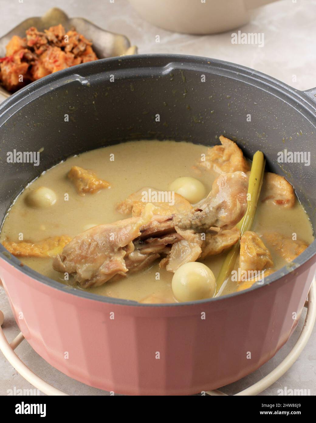 Frisch zubereitetes Opor Ayam (Indonesisches Gelbes Hühnchen-Curry) für das Lebaran-Menü, in der Regel serviert mit Ketupat, Sambal Goreng ATI Kentang und Semur Telur. P Stockfoto