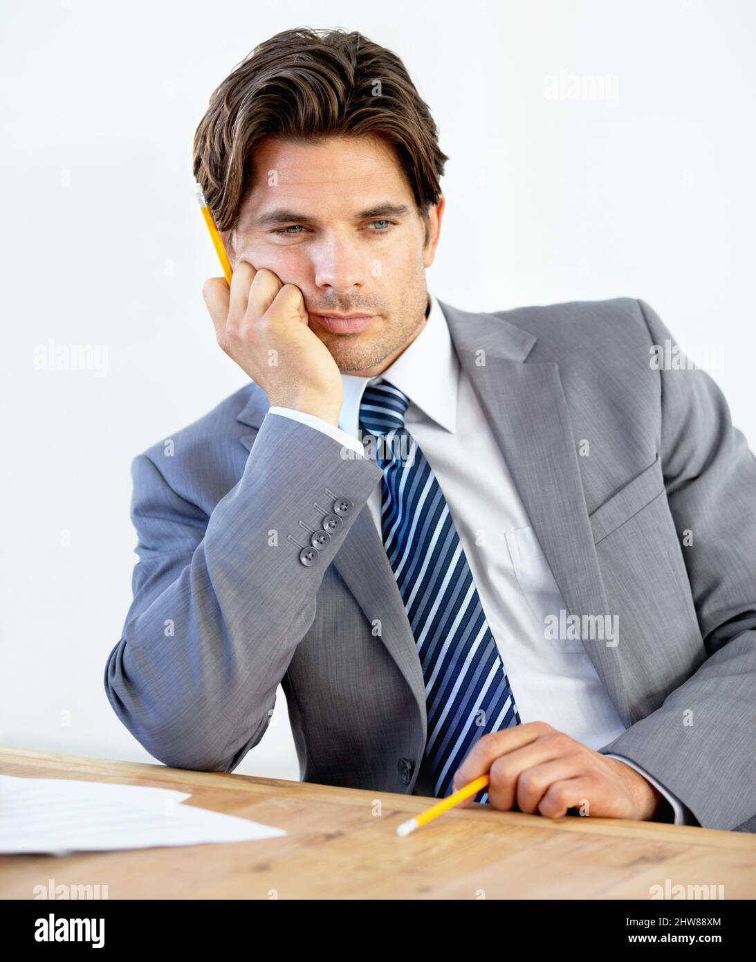 Eine Veränderung in der Karriere erforderlich. Gelangweilter junger Geschäftsmann, der an seinem Schreibtisch sitzt. Stockfoto