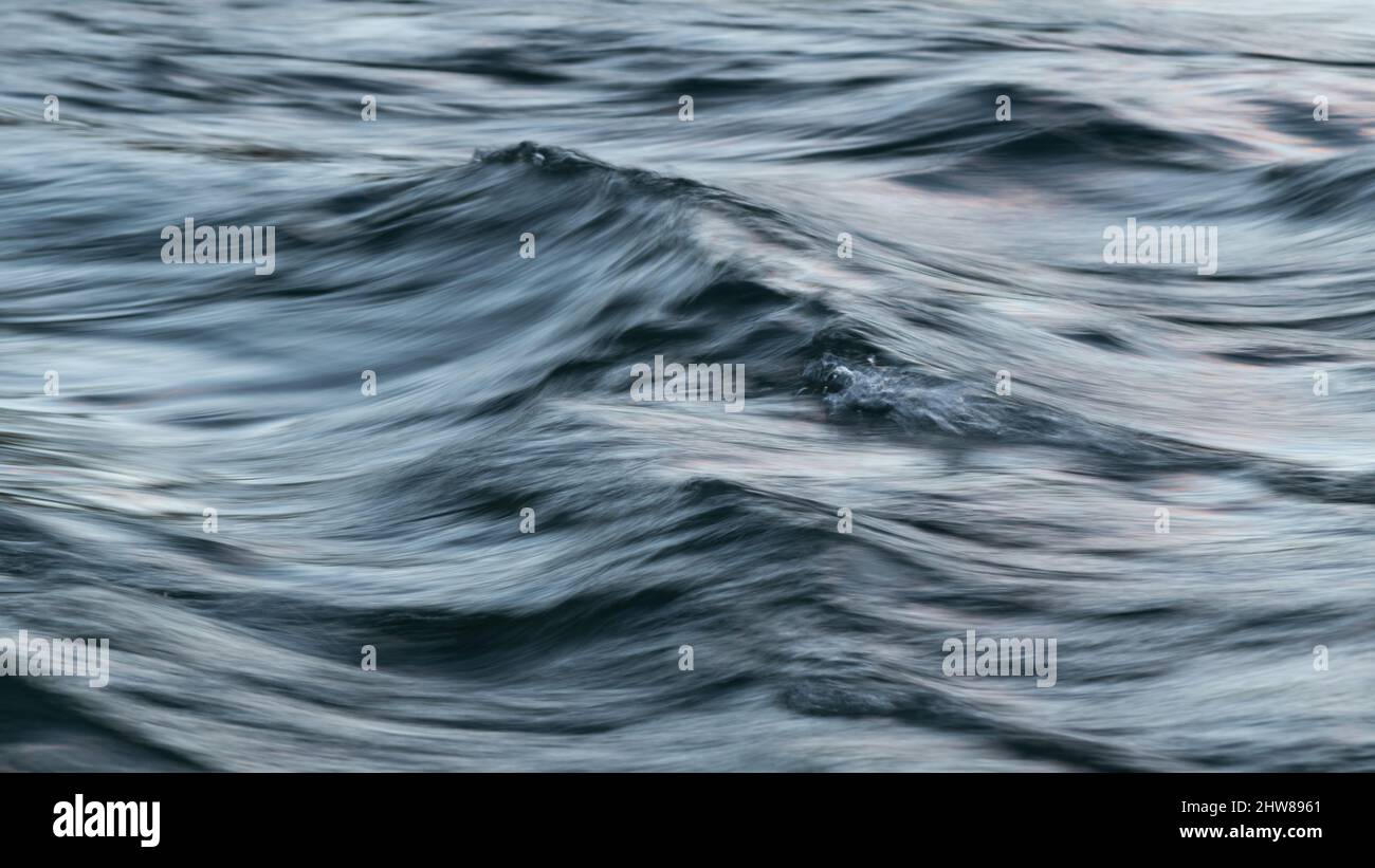 Abstrakte Landschaft aus gewelltem turbulentem Wasser im Wind mit seidiger Oberfläche bei langer Belichtung und Bewegungsunschärfe-Effekt Stockfoto