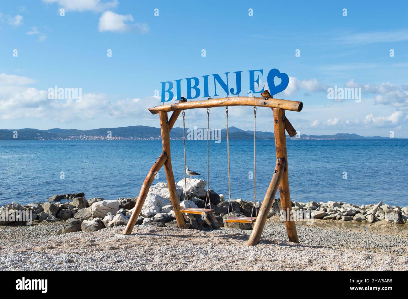 Bibinje, Kroatien - 06. Februar 2022: Schönes Küstendorf Bibinje in der Nähe von Zadar in Kroatien, Zeichen auf der hölzernen Schaukeln am Strand mit dem vie Stockfoto