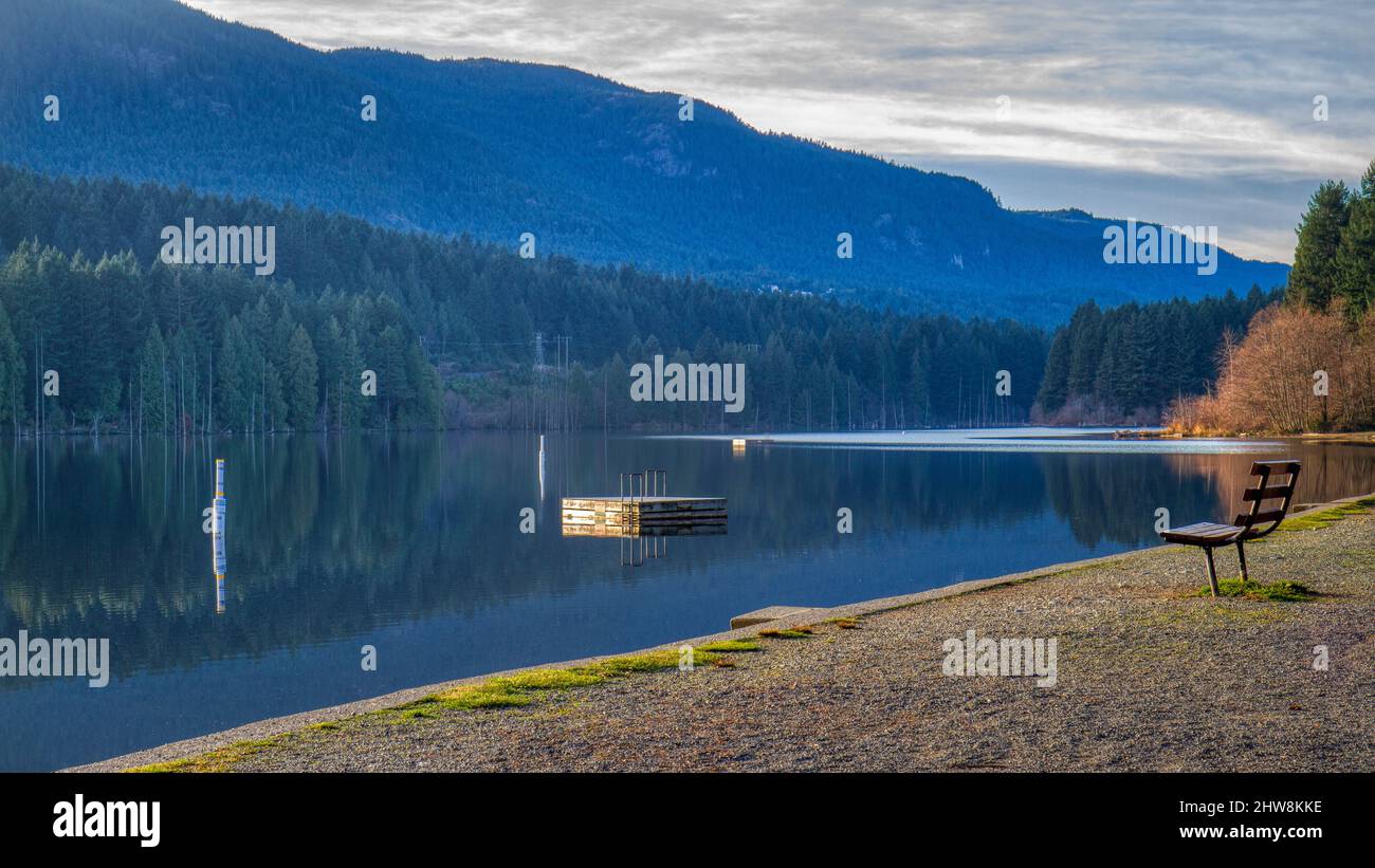 Holzplattform in einem See in der Nähe eines dichten Waldes auf einem Hügel in Vancouver Stockfoto