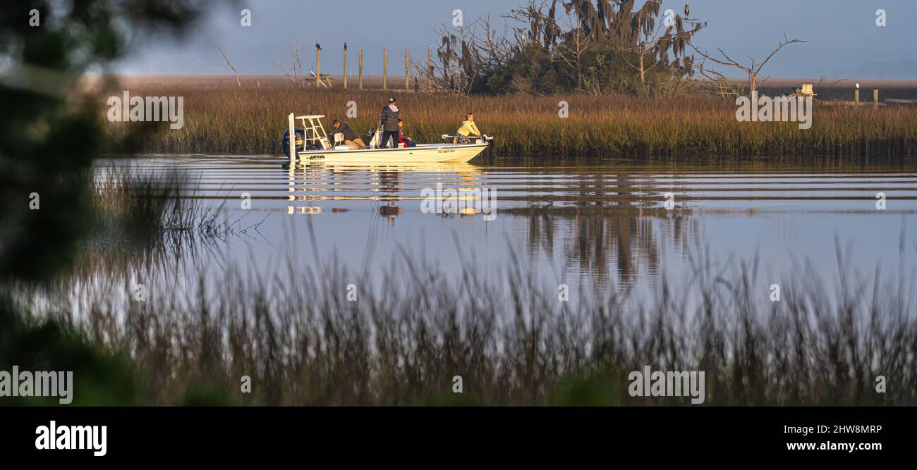 Familie auf einem Fischerboot kurz nach Sonnenaufgang im Gezeitensalz-Sumpf am Clapboard Creek entlang der Fort George Island in Jacksonville, Florida. (USA) Stockfoto