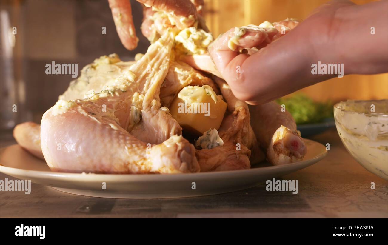 Rohes, mariniertes Hähnchen zum Backen im Ofen. Nahaufnahme der Frau Hand Putting weiße