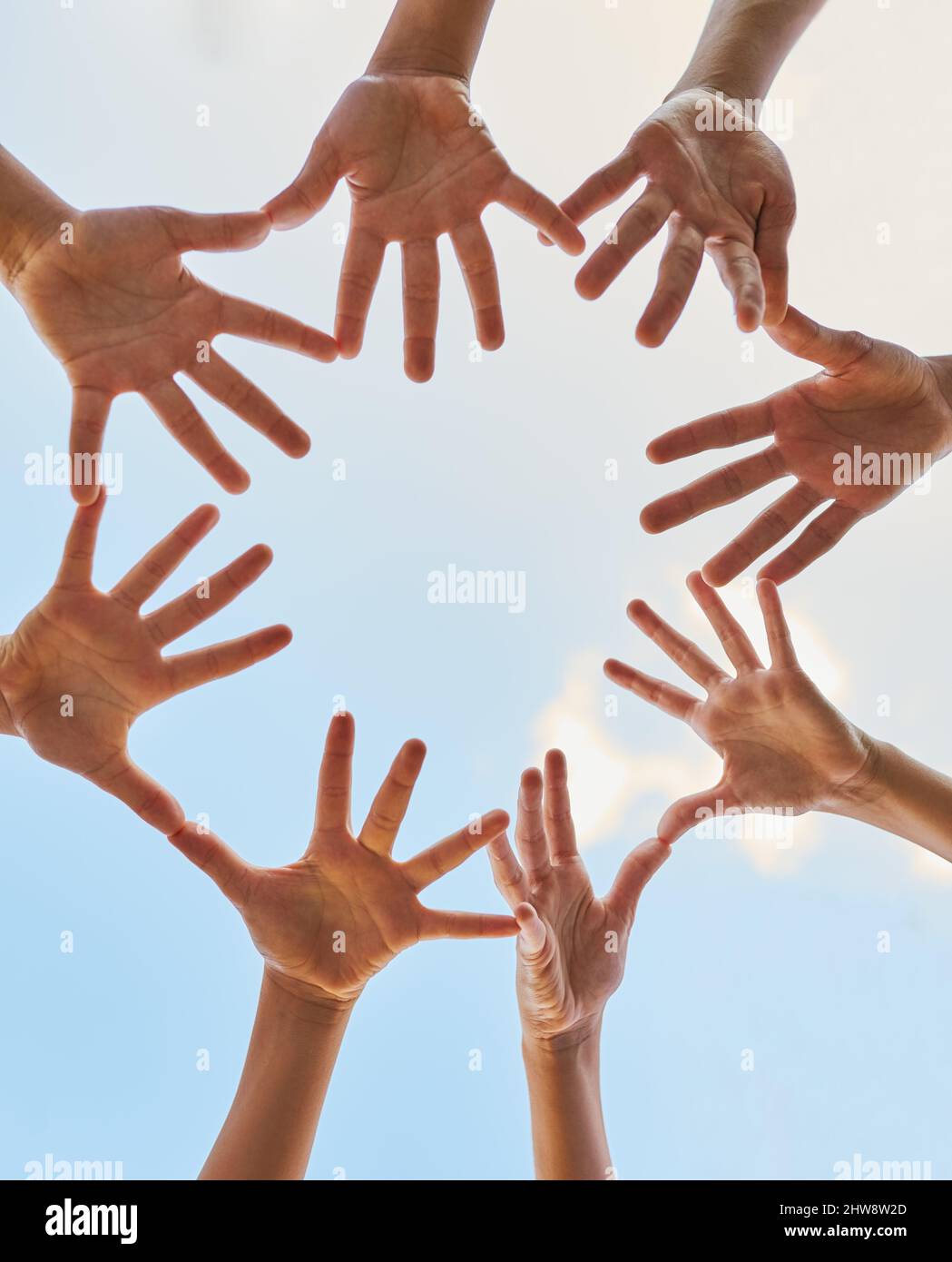 Wir alle haben die Macht, etwas zu bewirken. Aufnahme einer Gruppe von Kindern, die ihre Hände im Freien zusammenfügen. Stockfoto
