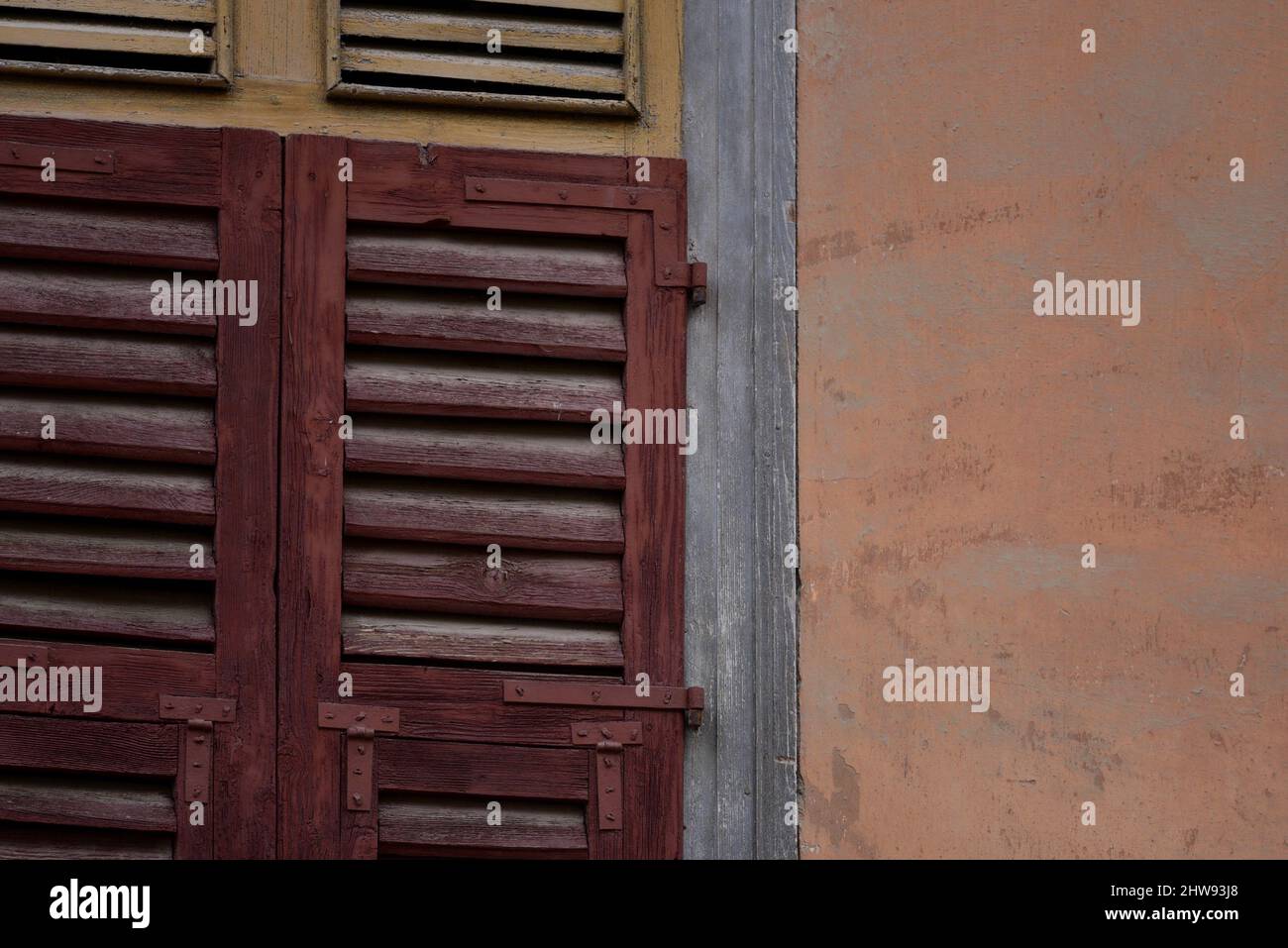 Altes traditionelles Landhaus zweifarbige Fensterläden aus Holz an einer venezianischen Stuckwand in Nafplio, Griechenland. Stockfoto