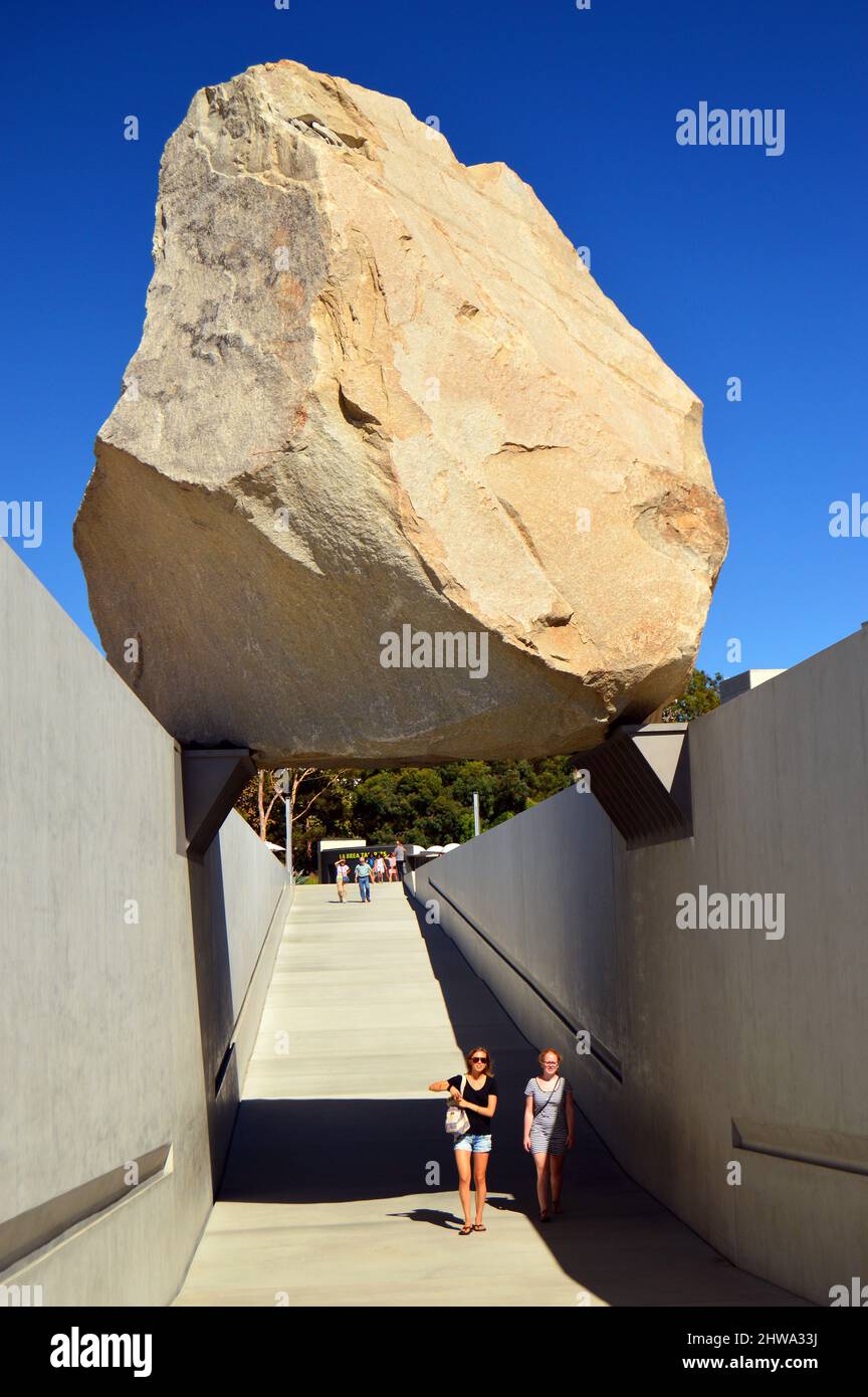Zwei Frauen gehen im Los Angeles County Museum of Art unter einem großen Felsbrocken, dem sogenannten Levitated Mass, spazieren Stockfoto