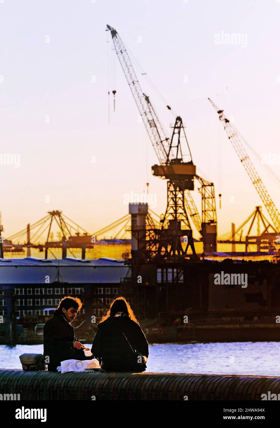 Zwei Personen vor Hafenkranen an der Norderelbe in Altona, Hafen Hamburg, Deutschland, Hamburg Stockfoto