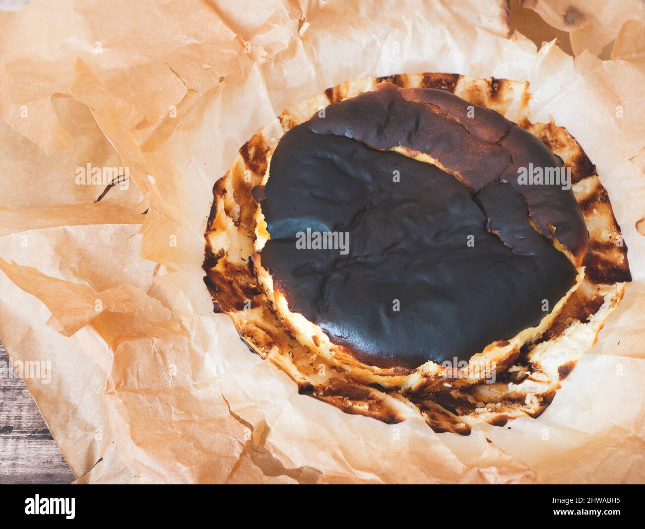 Baskischer gebrannter Käsekuchen mit sattem dunklem Oberteil. Spanischer Kuchen mit verbrannter Optik, Draufsicht Stockfoto