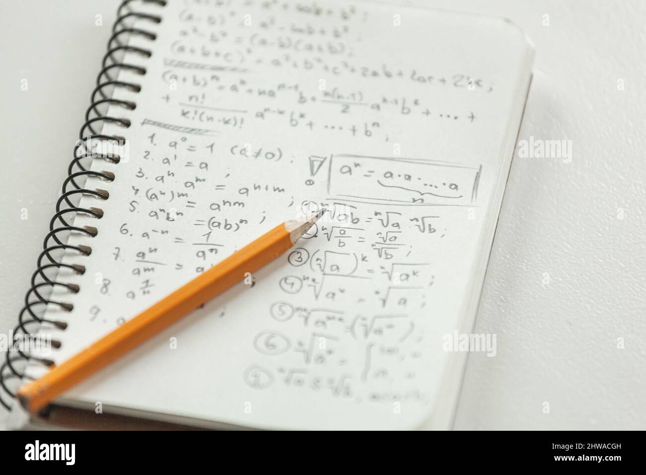 Mathematische Formeln werden mit Bleistift auf ein Stück Papier geschrieben, math PR Stockfoto